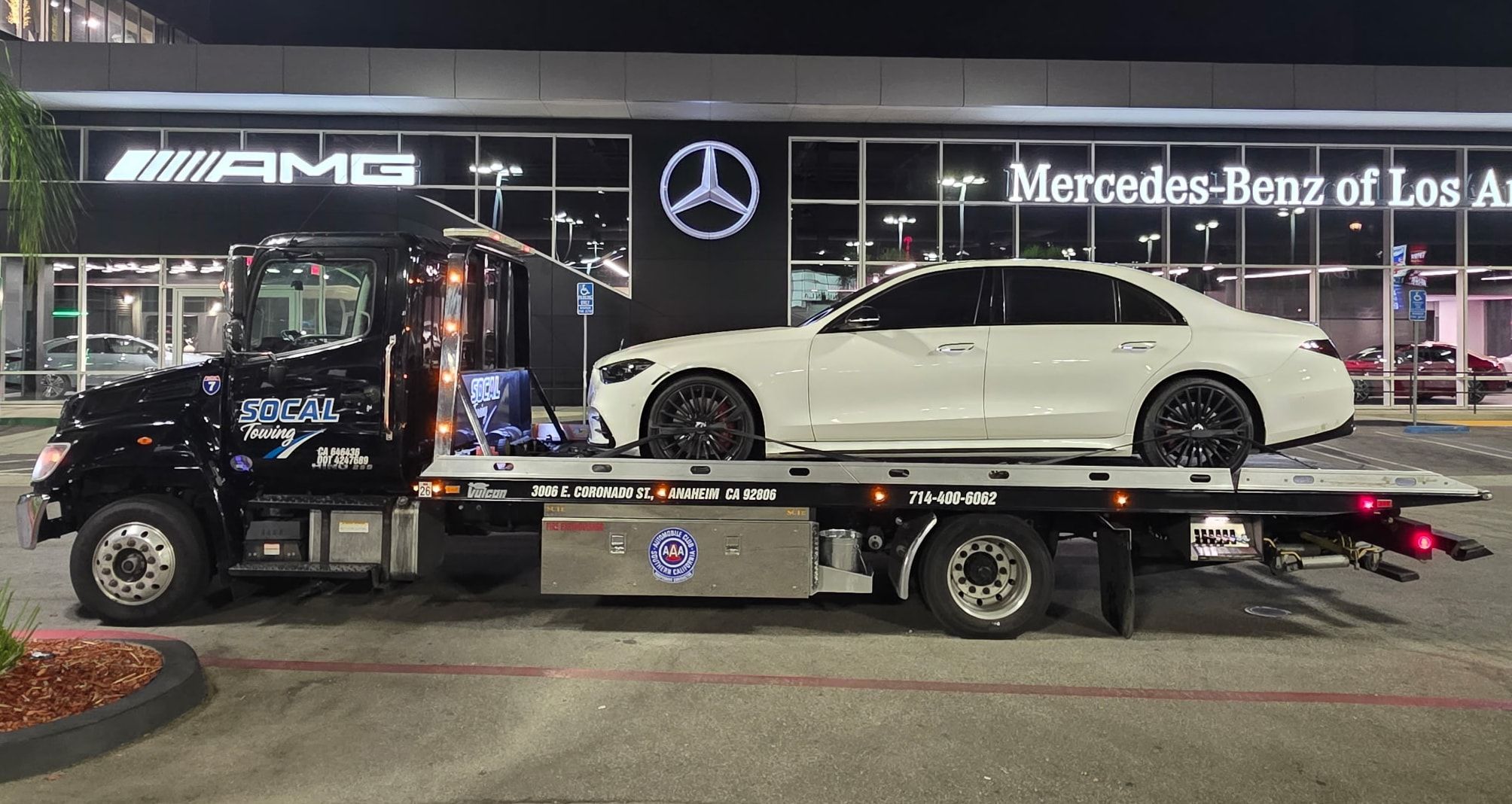 SoCal Towing flatbed delivering a Mercedes-Benz at night